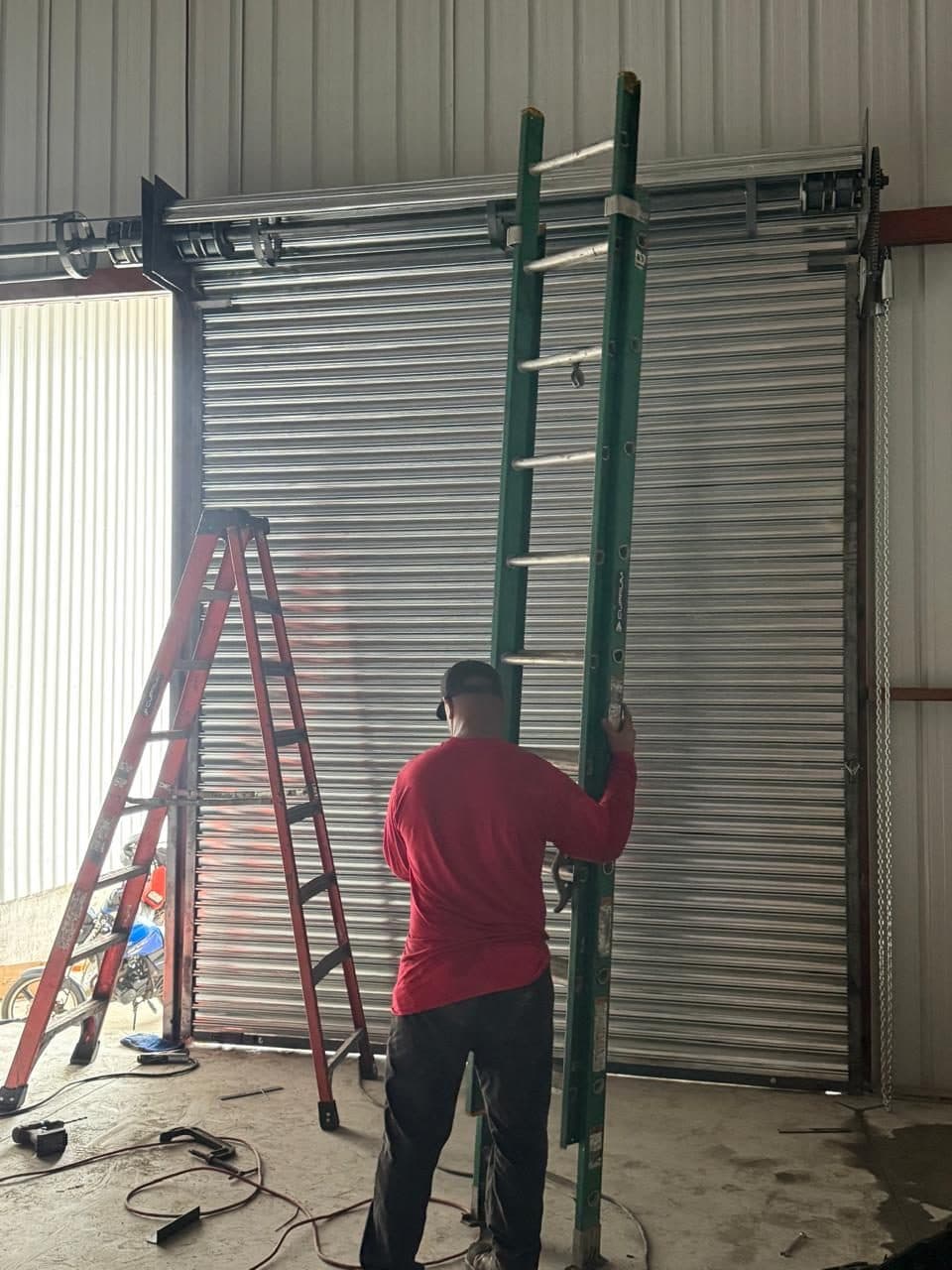 Técnico de FAMESEG terminando la instalación de una cortina metálica en una bodega